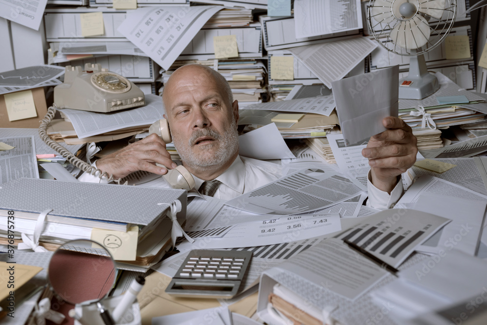 Stressed businessman overwhelmed by work