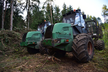 Crane forwarder machines at during clearing of a plantation. Wheeled harvester transports raw timber from the felling site out to a road for collection by a truck. Harvesters, forest Logging machines