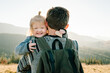 © Serhii - The daughter hug father on nature. Dad with backpack and child walk in the autumn. Family spending time together in mountain on vacation. Holiday trip concept. World Tourism Day. back view.