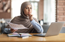 Pensive Muslim Woman Manager Working While Sitting At Cafe
