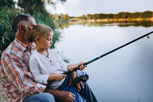 Grandfather And Grandson Fishing Outdoor On The Lake, Little Boy Looking At The Camera