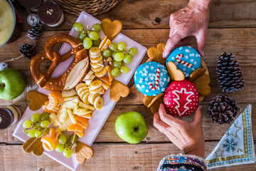 Wall Mural - Top view of christmas eve winter style cakes donuts with decorations - people eating sweet food and enjoy party celebration - wooden style table