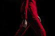 Cropped female fashion model in red stylish classy suit jacket and pants walking runway on the Fashion Show. Close up designer fashion details. Catwalk Fashion Week