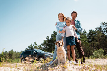 Wall Mural - Selective focus of family looking at golden retriever during weekend