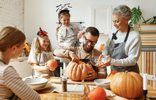 Multi Generational Family Preparing For Halloween In Kitchen.