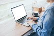 © panitan - computer mockup blank screen.hand woman work using laptop with white background for advertising,contact business search information on desk at coffee shop.marketing and creative design