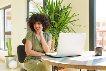 Wall Mural - young pretty arab woman with a laptop on a table. work at home c