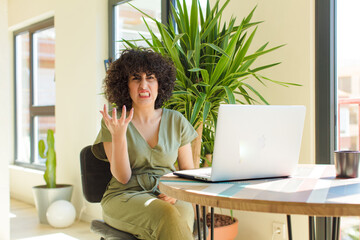 Wall Mural - young arab woman working at home with a laptop