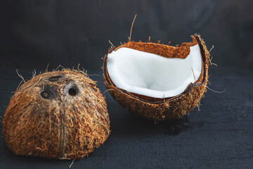 Coconut cut in half on a black background