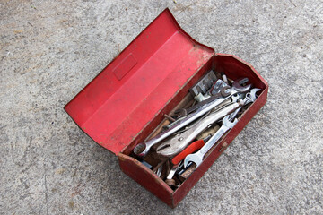 Red metal tool box on concrete floor.