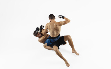 Two professional MMA fighters boxing isolated on white studio background. Top view of couple of muscular athletes. Sport, healthy lifestyle, competition, dynamic and motion, action concept. Copyspace.