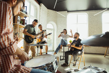 Inspiration. Musician Band Jamming Together In Art Workplace With Instruments. Caucasian Men And Women, Musicians, Playing And Singing Together. Concept Of Music, Hobby, Emotions, Art Occupation.