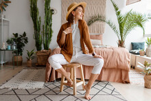 Fashionable Image Of Happy Woman In Straw Hat Posing Over Bohemian Interior Background. Straw Hat , Linen  Closes. Natural Make Up. Full Lengt.