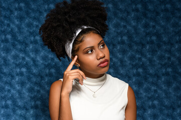 Wall Mural - Afro-Brazilian teenager thoughtful in a distant blue background