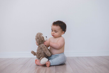 Wall Mural - Baby playing with his teddy bear 