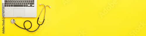 Fotografía Stethoscope keyboard laptop computer isolated on yellow background