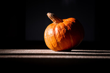 Orange pumpkin lying on the desk. The pumpkin is prepared for cutting for halloween. 