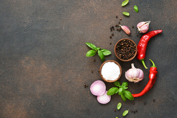 Set of spices, garlic, fresh basil and chili on a concrete background. View from above.