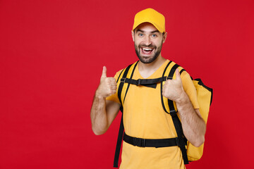 Wall Mural - Delivery employee man guy male 20s in yellow cap t-shirt uniform thermal bag backpack with food work as courier isolated on red background studio. Service during quarantine coronavirus covid-19 virus.