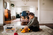 © Cavan Images - Toddler boy sitting inside putting together toy tractor