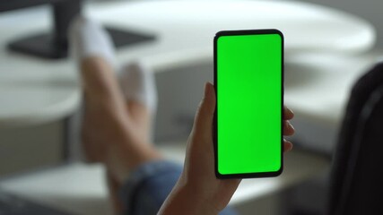 Handheld Camera: Point of View of Woman at Modern Room Sitting on a Chair Using Phone With Green Mock-up Screen Chroma Key Surfing Internet Watching Content Videos Blogs Tapping on Center Screen