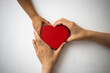 © hidez - 赤いハートを掴む子供と大人の手