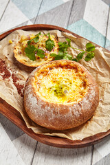 Canvas Print - Cheese soup served in round bread loaf