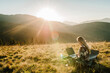 © Serhii - Woman working outdoors with laptop sitting in mountains. Concept of remote work or freelancer lifestyle. Cellular network broadband coverage. internet 5G. Hiker tourist enjoying valley view sunset.