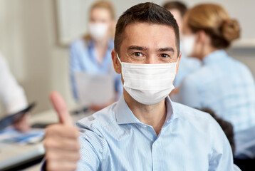 Sticker - business, people and pandemic concept - businessman wearing face protective medical mask for protection from virus disease showing thumbs up at office