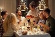 © Syda Productions - holidays, celebration and people concept - happy smiling friends having christmas dinner at home in evening