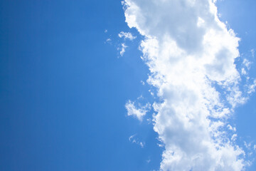 White fluffy clouds in a bright blue sky on a sunny day.