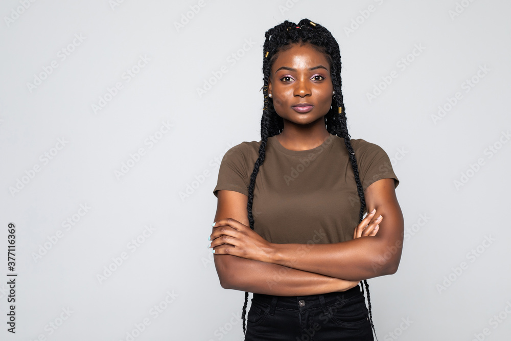Portrait of african woman with arms folded standing over gray ...