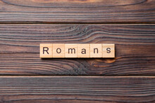 Romans Word Written On Wood Block. Romans Text On Table, Concept