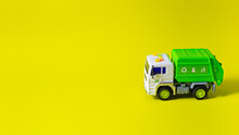 The Toy Is A Garbage Truck Green With A White Body On A Yellow Background Banner With A Place For Text For A Toy Store. Children's Toys Typewriter.
