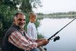 © cherryandbees - grandfather with his grandson fishing outdoor on the lake