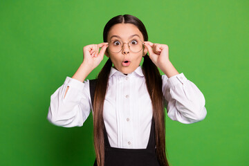 Poster - Photo portrait of shocked girl using glasses for the first time isolated on vivid green colored background