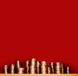 Pile of euro golden coins on red background, blurred in the background, with free space to write