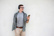 © Pituk - Young Caucasian man listening to music in headphones on gray wall background