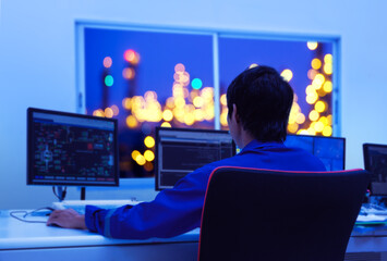 Young Technician monitoring industrial plant in control room, engineer work