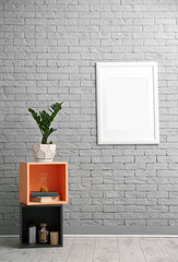 Poster - Stylish room interior with empty poster on brick wall. Mockup for design