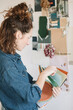 © Alberto Bogo/Stocksy - Focused Young Woman Choosing Fabric For Moodboard