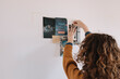 © Alberto Bogo/Stocksy - Anonymous Young Woman Selecting And Hanging Pictures For Moodboard