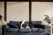 © Léa Jones/Stocksy - boy reading book on the sofa with his dog