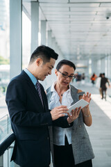 Business man  showing colleague digital tablet and explaining stock photo