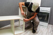 worker assembles furniture in the kitchen. furniture assembly service