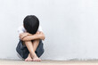 © lllonajalll - A boy sitting alone with sad feeling. Asian little child covered his face with his hands in fear.  Domestic Family violence concept.