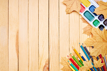 Wall Mural - back to school concept. education and study stationery on a wooden desk. above view. decorated with yellow maple leaves