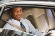 © SuperStock - African businessman riding in back seat of car