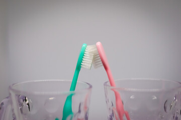 Male toothbrush kissing female toothbrush in white background