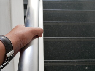 closeup of man hand on the handrail or railing at office.